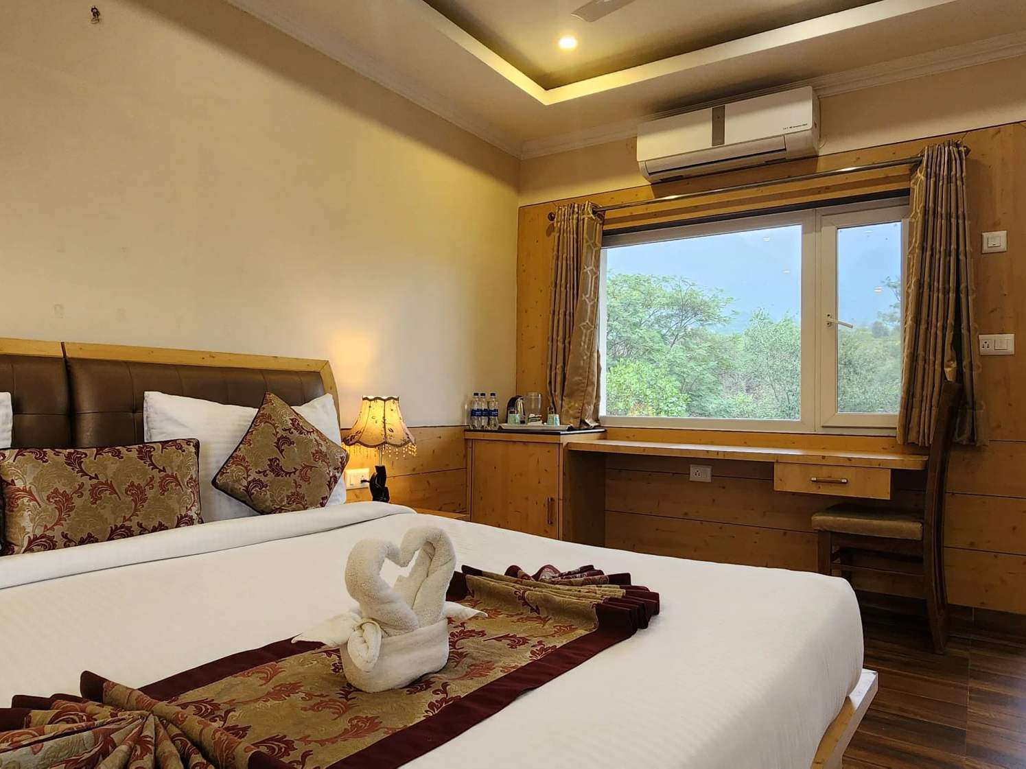 Master Room: a king-size bed facing large windows onto the trees