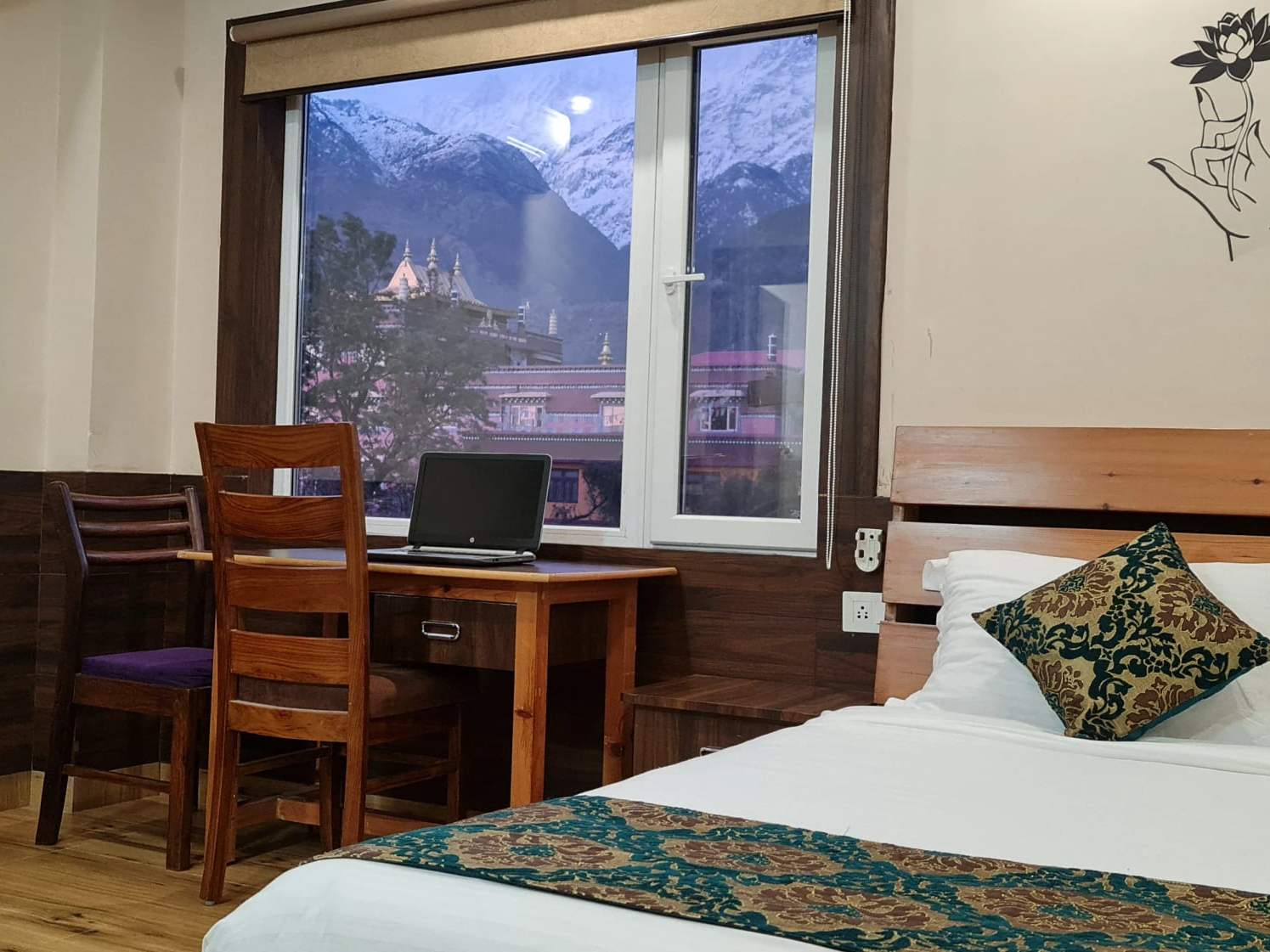 Premium room: a work desk at a window looking out to snow-capped mountains and a monastery roof