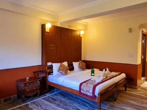 Budget Double room: a double bed with a red runner and a wood-panelled wall