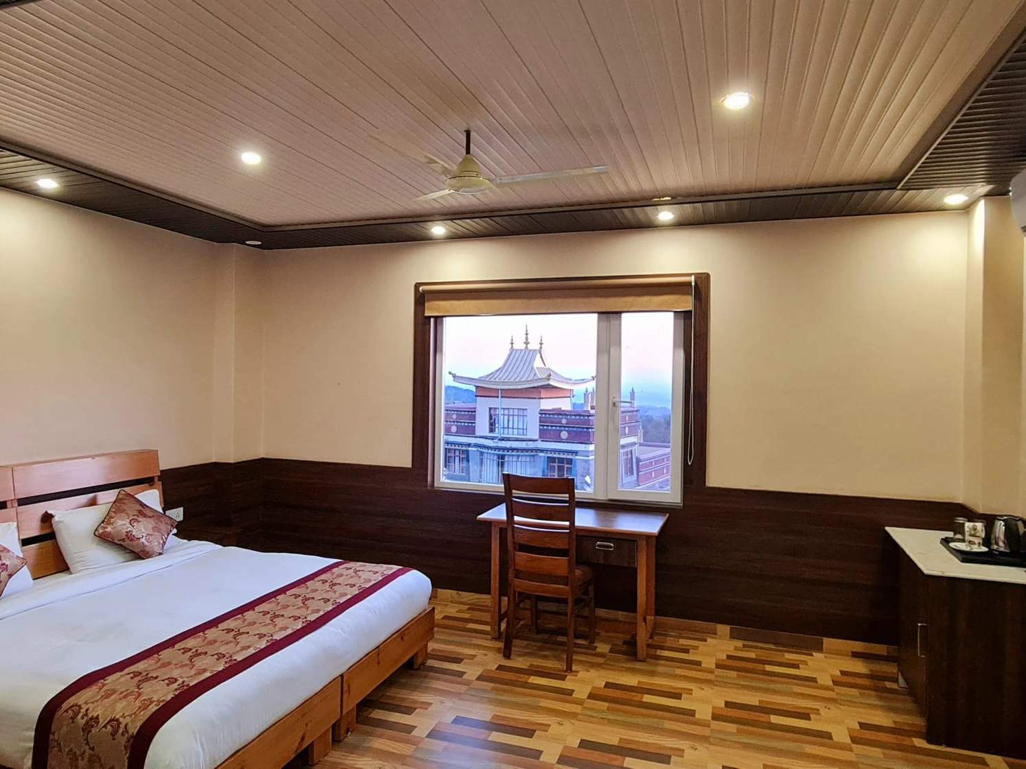 Premium Mountain View room: a king-size bed, a desk, and a window onto a monastery roof