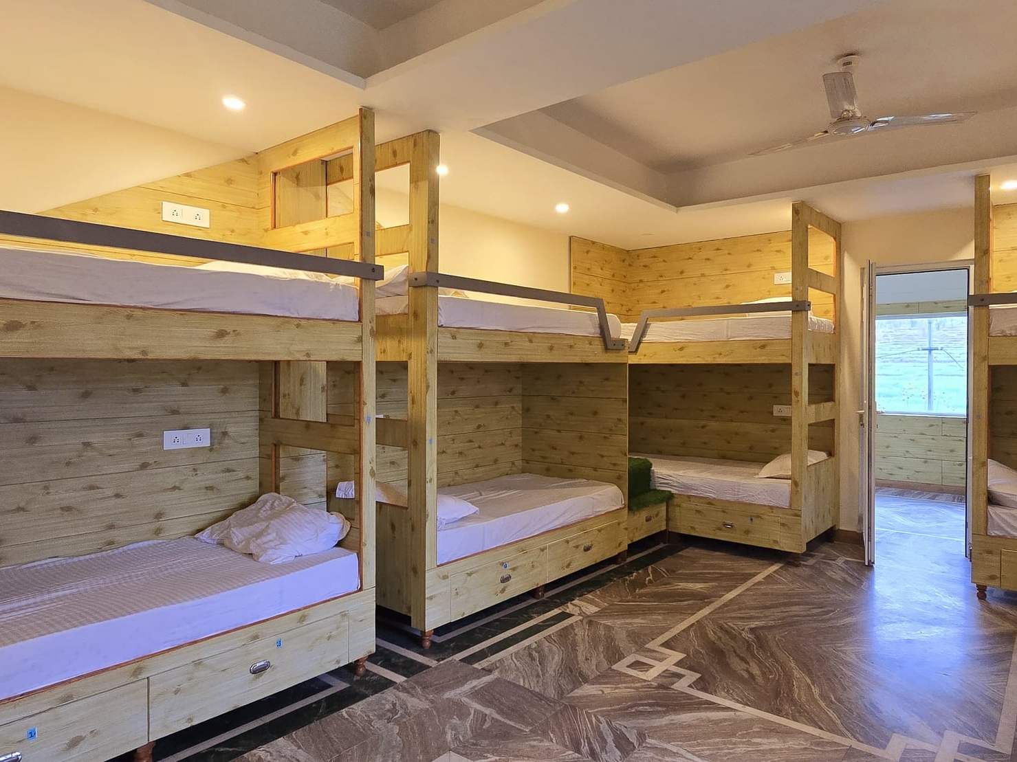 The bunk room: rows of pine bunk beds with fresh linen