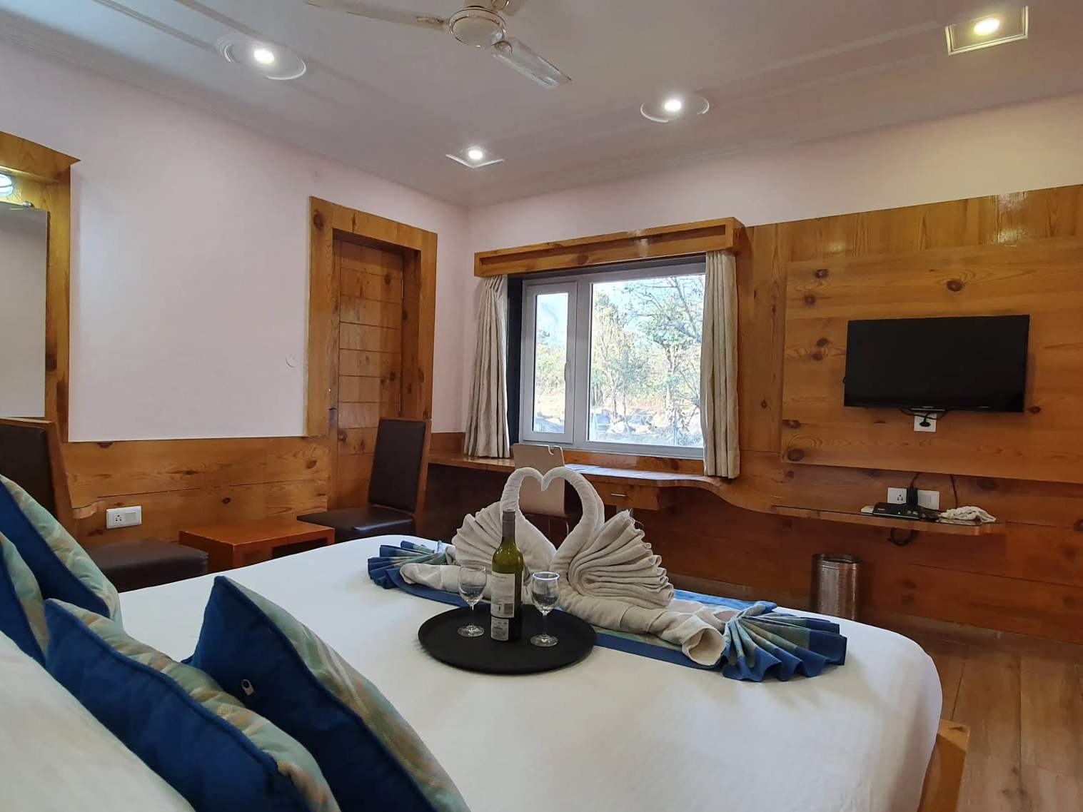 Junior Suite bedroom with a king-size bed, towel swans and a TV