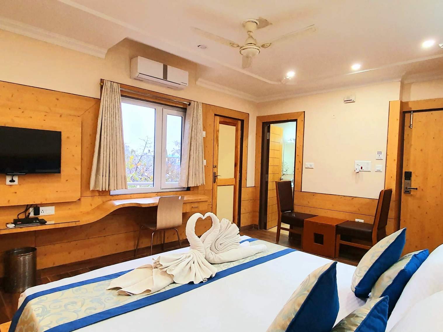 Luxury Pocket room: a king-size bed with a towel swan, wall-mounted TV and pine-panelled walls
