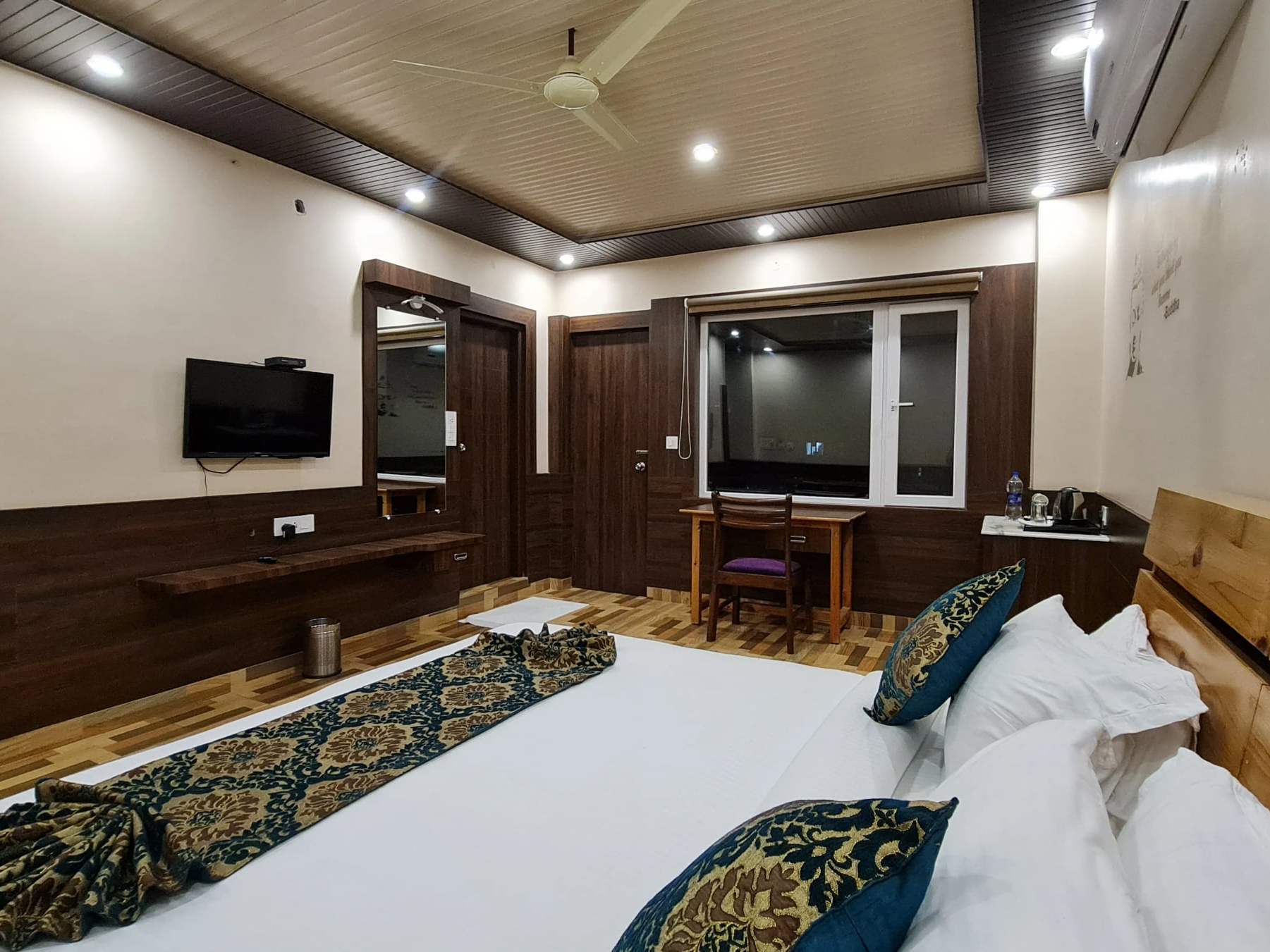 Superior Mountain View room: a wide king-size bed with patterned cushions and a TV wall
