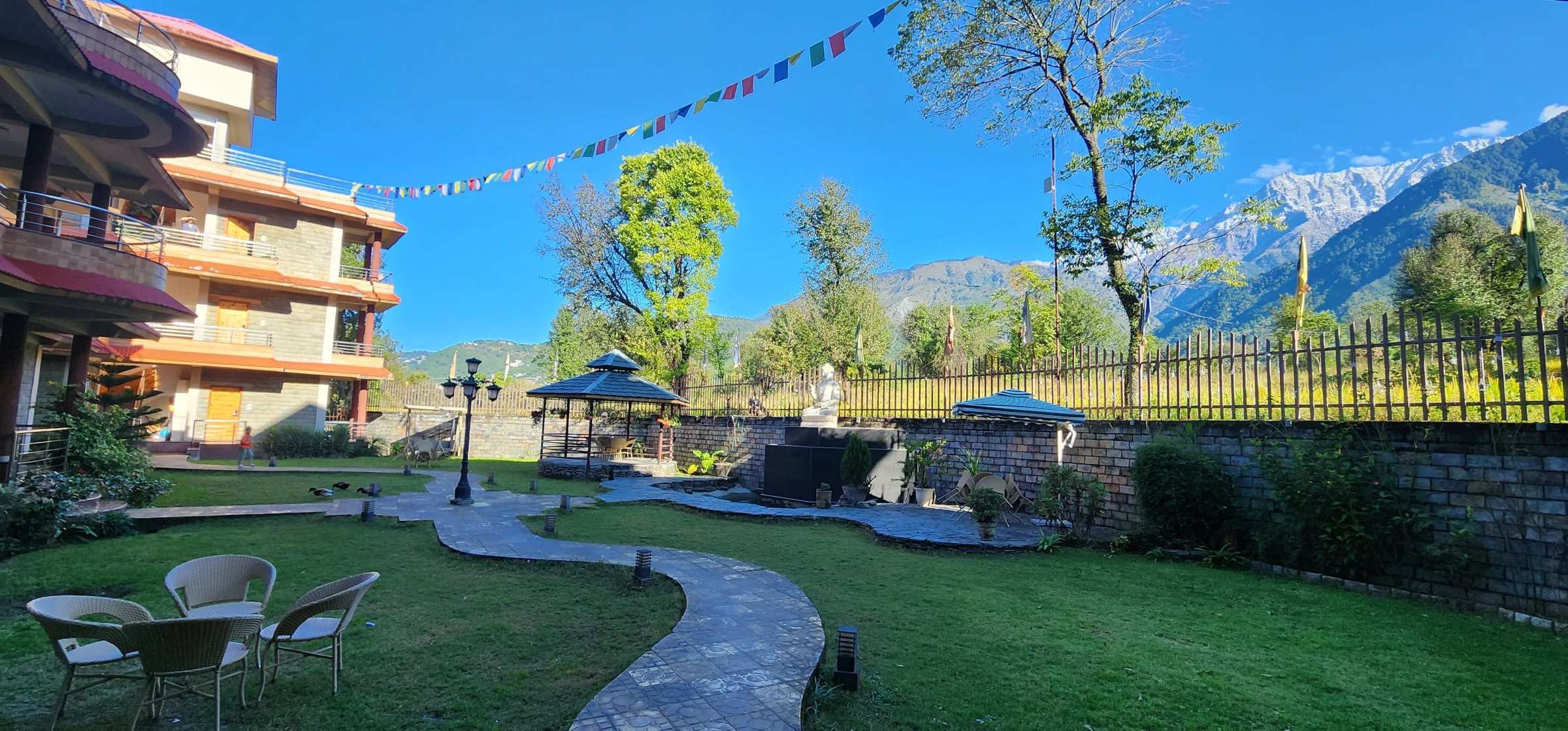 The Quartz garden with a gazebo, lawns and prayer flags under a blue sky