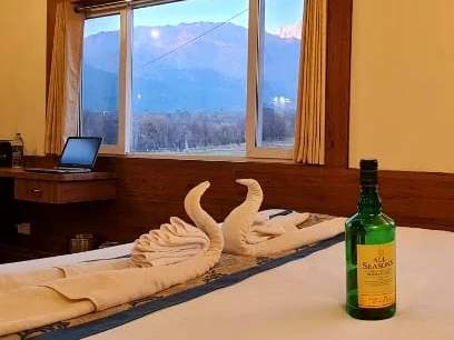 A desk and window looking out to the mountains, with towel swans on the bed