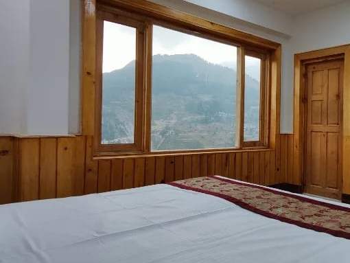 Pine-framed windows looking over the mountains near Sach Pass