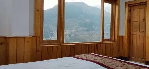 Pine-framed windows looking over the mountains near Sach Pass