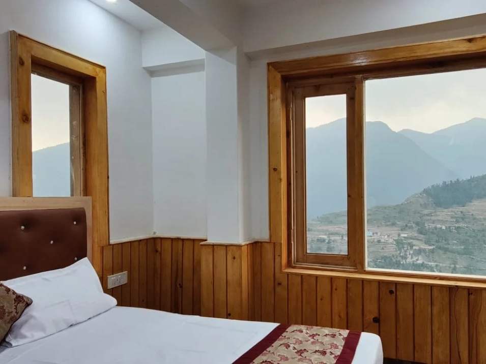 A pine-panelled room at Hotel Diwan Sachpass with a mountain view through the window