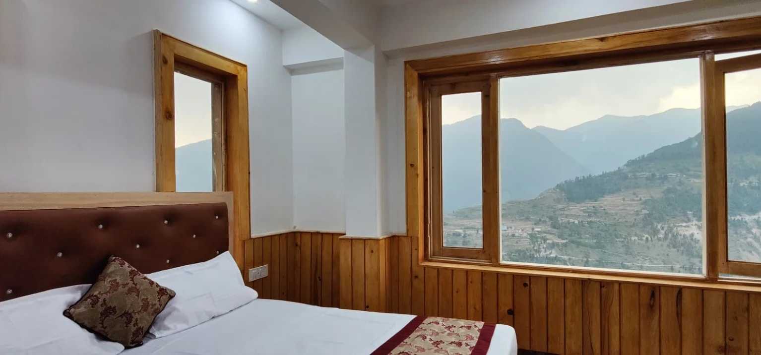 A pine-panelled room at Hotel Diwan Sachpass with a mountain view through the window