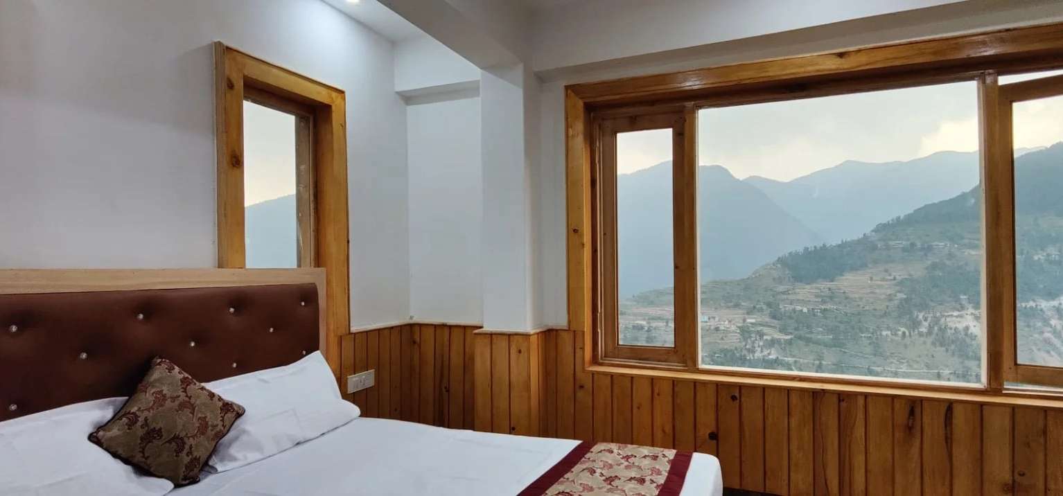A pine-panelled room at Hotel Diwan Sachpass with a mountain view through the window